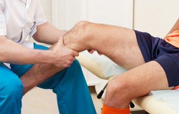 The doctor examines the knee for arthrosis